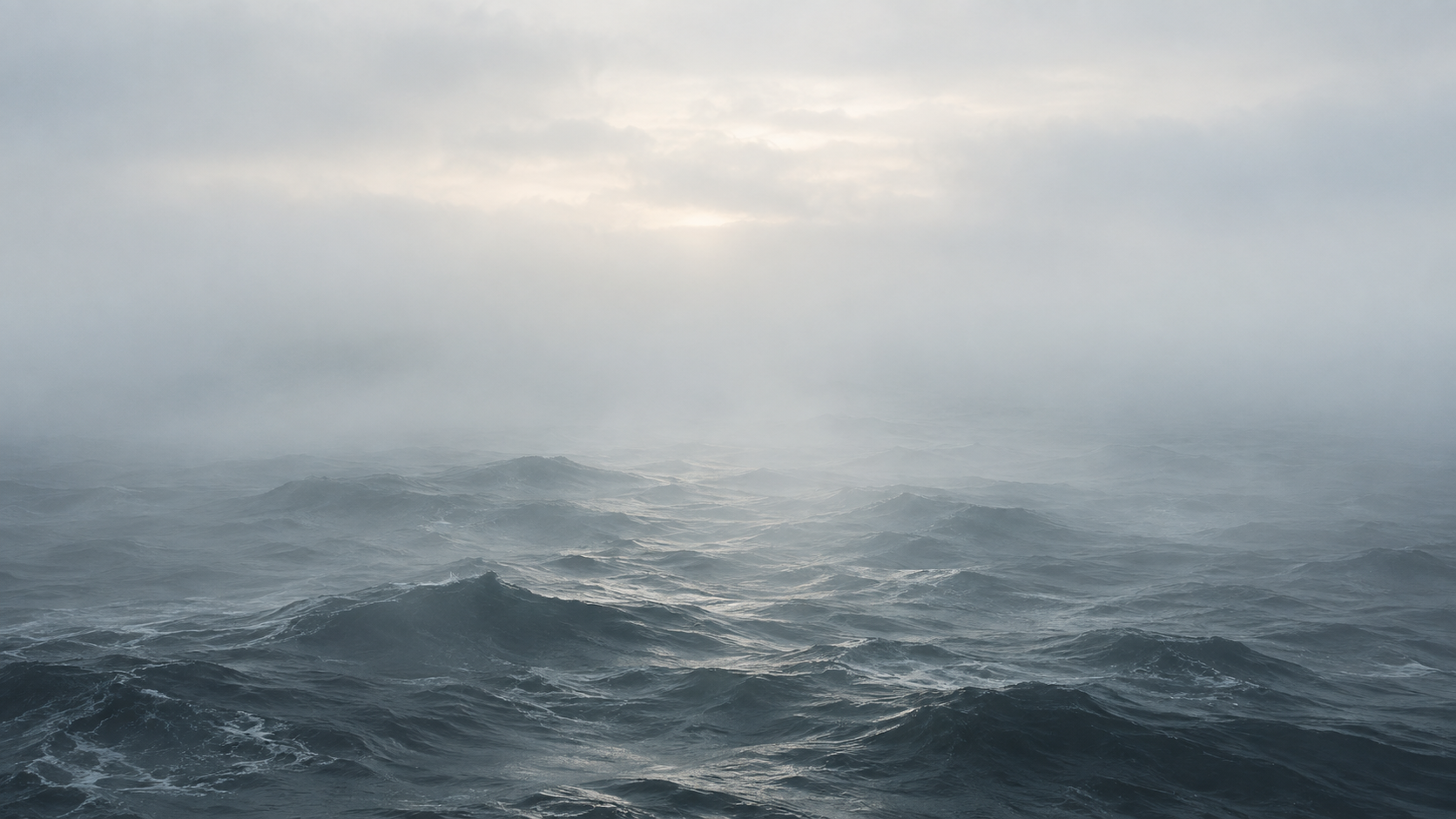 Sea waves beneath a mist-obscured horizon.